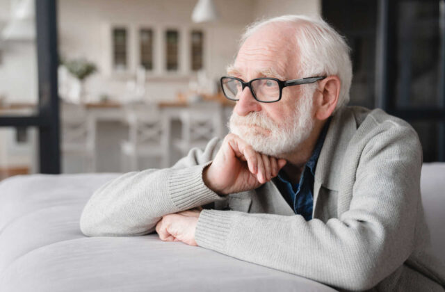 An elderly man sitting and experiencing disorientation and confusion.